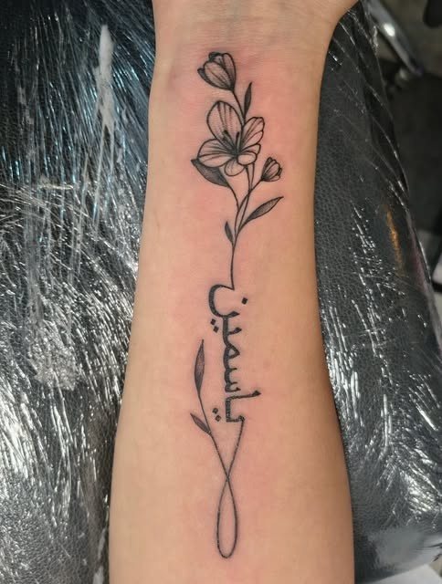 Tatuaggio fine line, fiori e scritta